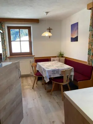 a living room with a dining room table and chairs at Schneiderhof, Chalet, Urlaub auf dem Bauernhof in Ridanna