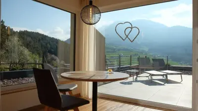 two chairs on a balcony with a view of a mountain at Runk Apartments in Siusi