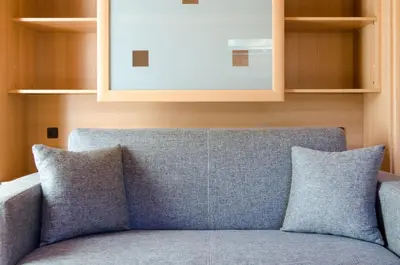 a blue couch with two pillows in a room at Runk Apartments in Siusi