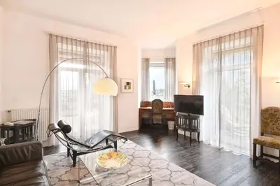 a living room with a couch and a tv at Villa Tivoli in Merano