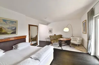 a bedroom with two beds and a table and a chair at Villa Tivoli in Merano