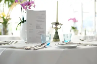 a white table with plates and silverware on it at Villa Tivoli in Merano