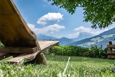 a house on a hill with mountains in the background at HAUSERHOF Farmhouse with Dolomite View in Villandro