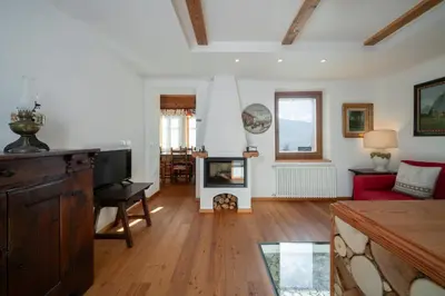 a living room with a fireplace and a red couch at Casa Gialla in Varena