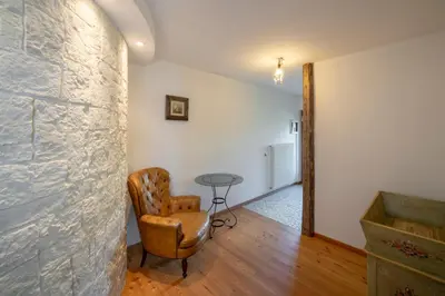 a living room with a chair and a table at Casa Gialla in Varena