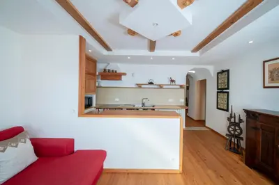 a living room with a red couch and a kitchen at Casa Gialla in Varena