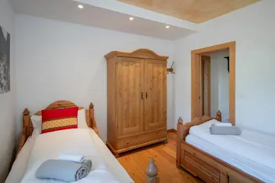 a bedroom with two beds and a wooden cabinet at Casa Gialla in Varena