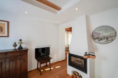 a living room with a fireplace and a tv at Casa Gialla in Varena