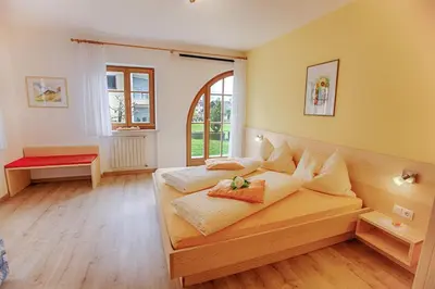 a bedroom with a large wooden bed with pillows at Residence Prunarhof in Caldaro
