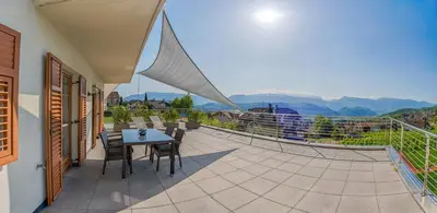 a balcony of a house with a table and chairs at Residence Prunarhof in Caldaro