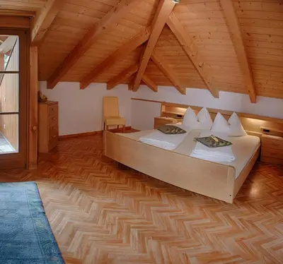 a bedroom with a bed and a wooden ceiling at Residence Prunarhof in Caldaro