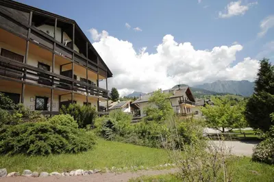 a kitchen with a table and a stove top oven at CASA 4 PIOPPI - 2 camere, balcone, garage Dolomiti Affitti in Cavalese