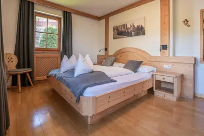 a dining room with a table and a clock on the wall at Residence Burghof in Siusi