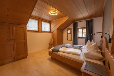 a bedroom with a large bed with a wooden headboard at Residence Burghof in Siusi