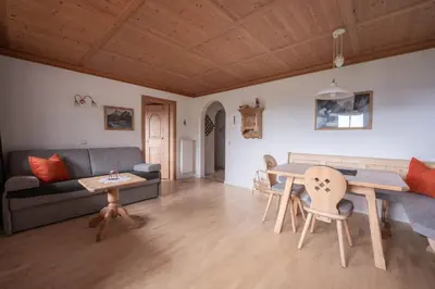 a dining room with a table and a tv at Residence Burghof in Siusi