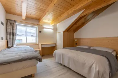 a bedroom with two beds and a window at Chalet Butterfly 3 in Mazzin