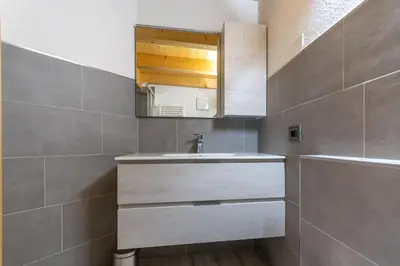 a bathroom with a sink and a mirror at Chalet Butterfly 3 in Mazzin