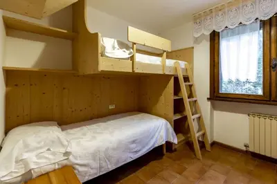 a bedroom with two bunk beds and a window at Des Alpes 3 in Canazei