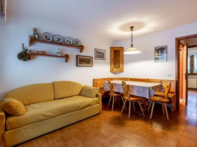 a living room with a couch and a table at Des Alpes 3 in Canazei