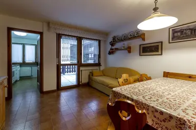 a living room with a table and a couch at Des Alpes 3 in Canazei