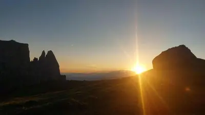 a sunset over the mountains with the sun setting at Planitzhof in Castelrotto