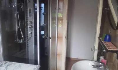 a bathroom with a shower and a toilet and a sink at B&B Signora Elvira in Capriana