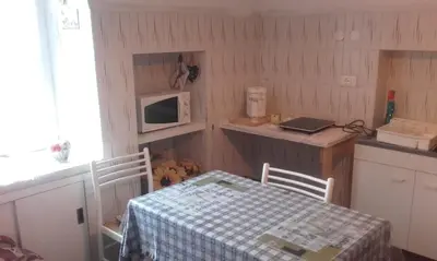 a small kitchen with a table and a microwave at B&B Signora Elvira in Capriana