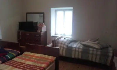 a bedroom with two beds and a mirror and a window at B&B Signora Elvira in Capriana
