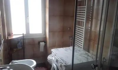 a bathroom with a shower and a toilet and a sink at B&B Signora Elvira in Capriana