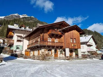 a large wooden building with a balcony in the snow at Cesa Alegra in Campestrin