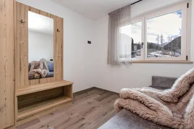 a living room with a mirror and a chair at Apartments Pragser Wildsee - by Familiaris in Braies