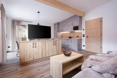 a living room with a flat screen tv and a couch at Apartments Pragser Wildsee - by Familiaris in Braies