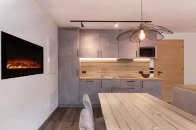 a kitchen with a wooden table and a fireplace at Apartments Pragser Wildsee - by Familiaris in Braies