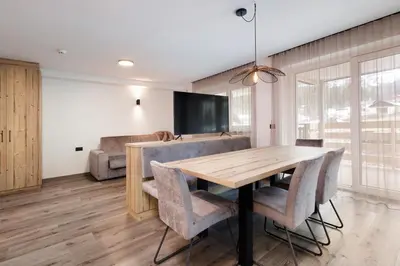 a dining room with a wooden table and chairs at Apartments Pragser Wildsee - by Familiaris in Braies