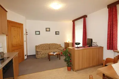 a kitchen with a table and chairs and a kitchen with at Appartamenti Lezuo Iris in Arabba