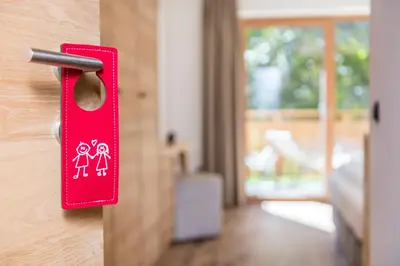 a red door handle with a couple on it at Hotel Weisses Rössl - Cavallino Bianco in Ortisei