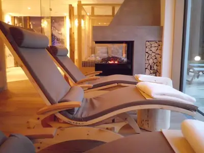 a row of chairs in a living room with a fireplace at Hotel Weisses Rössl - Cavallino Bianco in Ortisei