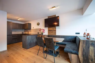 a kitchen with wooden cabinets and a wooden table and chairs at Apartment Villa Hetty in Ortisei