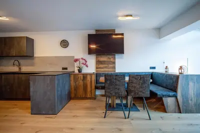 a kitchen with wooden cabinets and a table with chairs at Apartment Villa Hetty in Ortisei