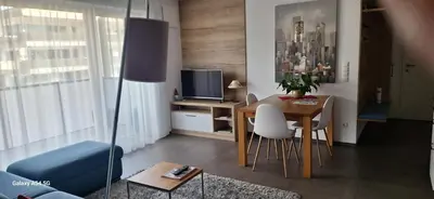 a living room with a table and a television at FeelHome Bruneck in Brunico