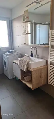 a bathroom with a sink and a washing machine at FeelHome Bruneck in Brunico