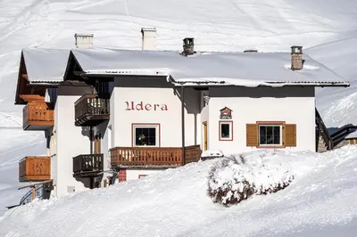 a house on top of a snow covered slope at Apartments UDERA in Selva di Val Gardena