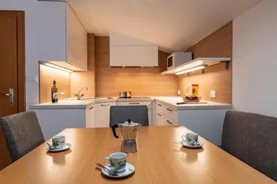 a kitchen with a wooden table with two cups on it at Apartments UDERA in Selva di Val Gardena