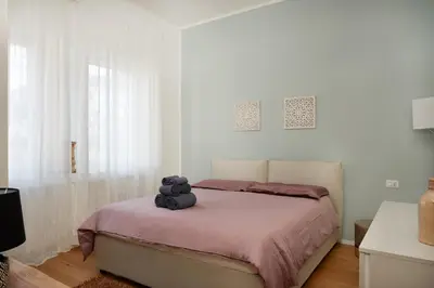 a teddy bear sitting on a bed in a bedroom at Duomo 55 MQ new flat in the centre of Bolzano in Bolzano