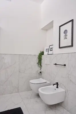 a white bathroom with a toilet and a sink at Duomo 55 MQ new flat in the centre of Bolzano in Bolzano