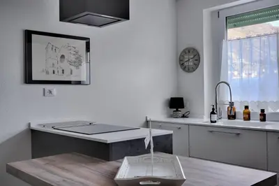 a kitchen with a sink and a clock on the wall at Duomo 55 MQ new flat in the centre of Bolzano in Bolzano