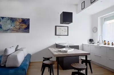 a living room with a table and a blue couch at Duomo 55 MQ new flat in the centre of Bolzano in Bolzano