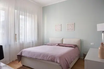a white bedroom with a bed and a window at Duomo 55 MQ new flat in the centre of Bolzano in Bolzano