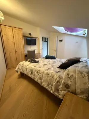 a bedroom with a bed with a comforter on it at Crystal House in Cavalese
