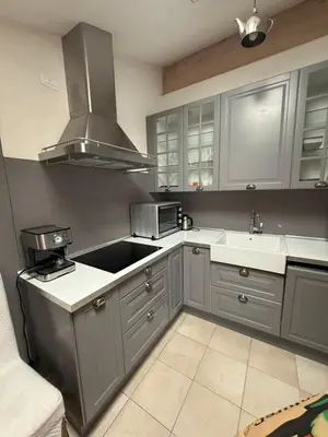 a kitchen with gray cabinets and a stove top oven at Crystal House in Cavalese
